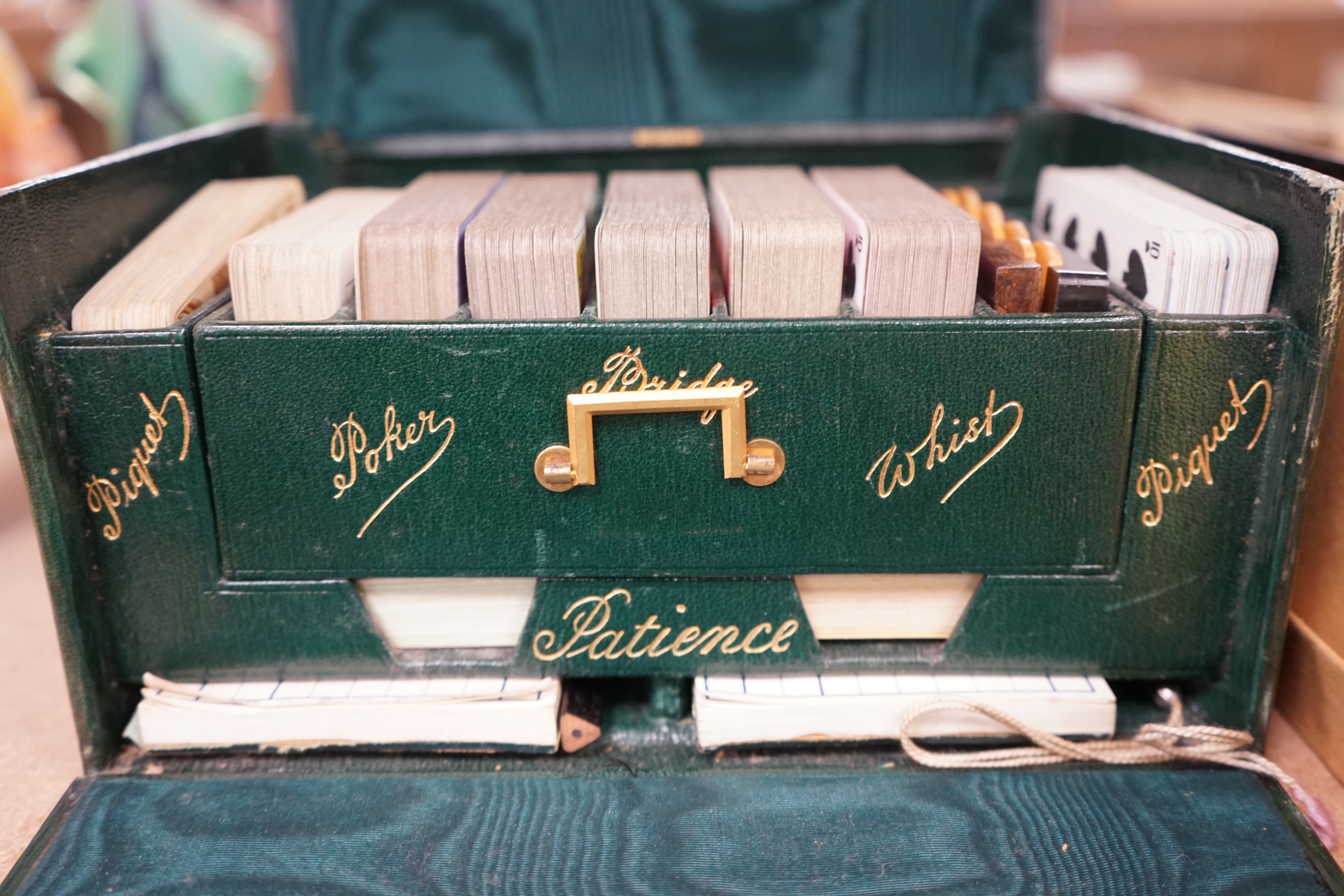 A Cook's patent stereoscope viewer and viewing cards together with a green Morocco leather playing cards box, box 12.5cm high x 24cm wide. Condition, games box poor, viewer and cards good